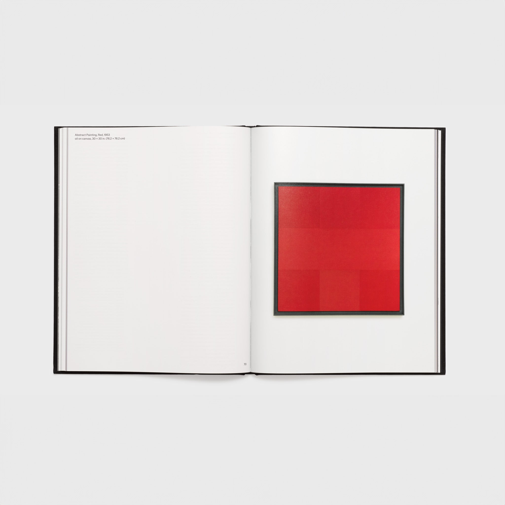 The book is opened to two pages with a red Ad Reinhardt work on the right page and the attribution on the other.