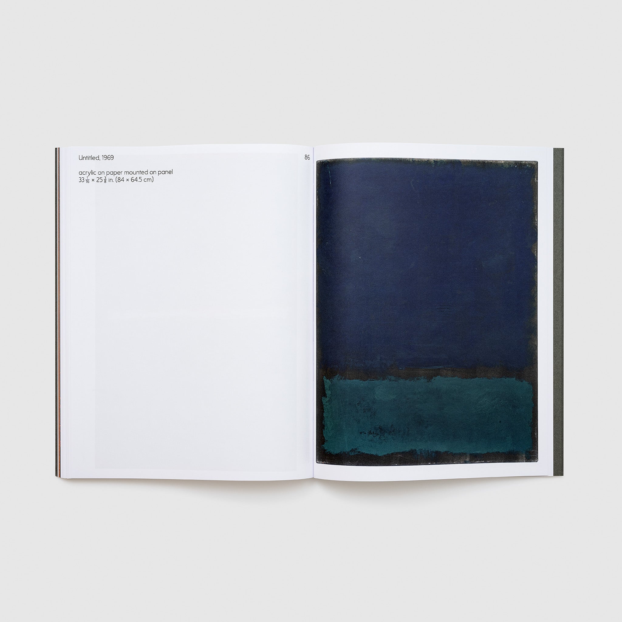 The book is open to two pages. The right page has a blue and black Rothko work and the left page has a description of the work.
