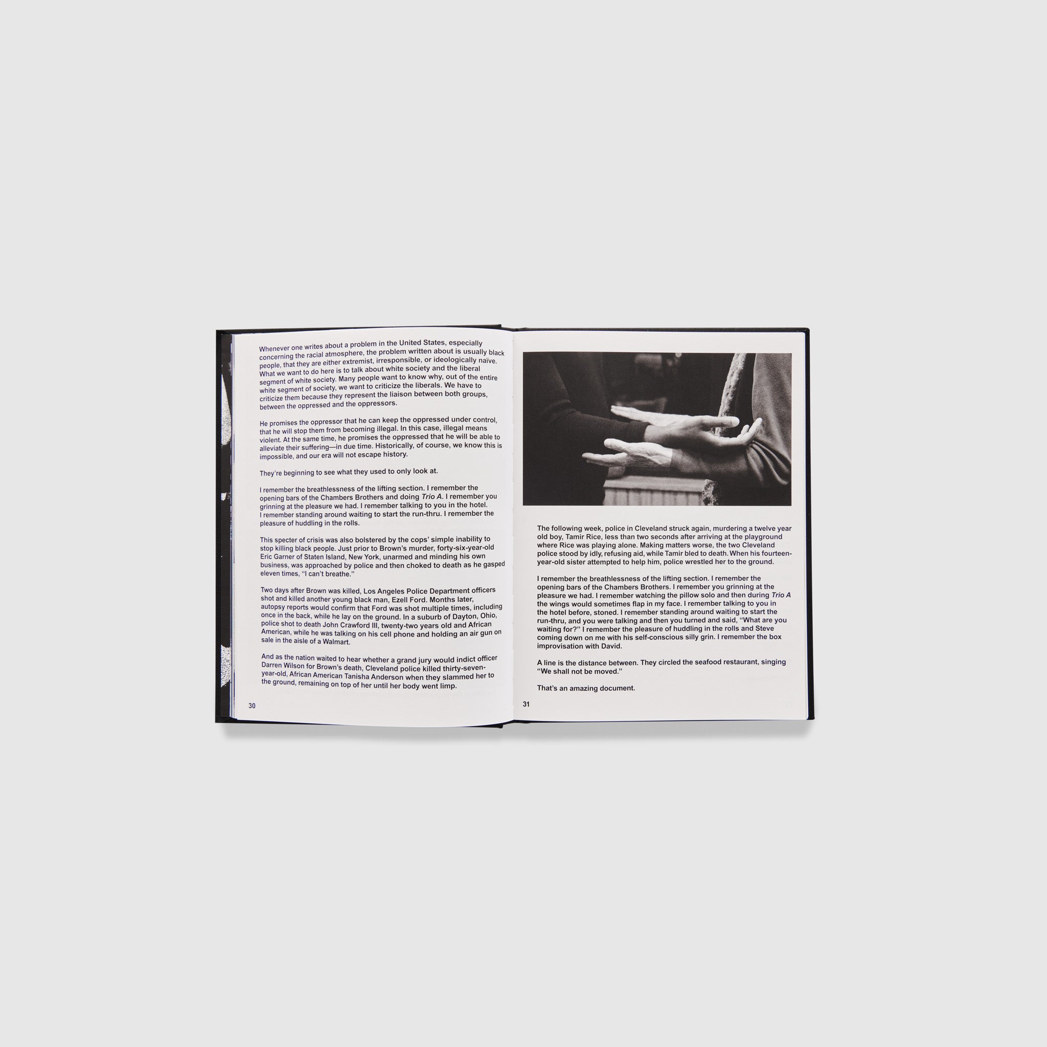 The book is open to pages 30 and 31 and contains an essay across both. There is a black and white image of two people standing with their hands on top of each other on the right page.