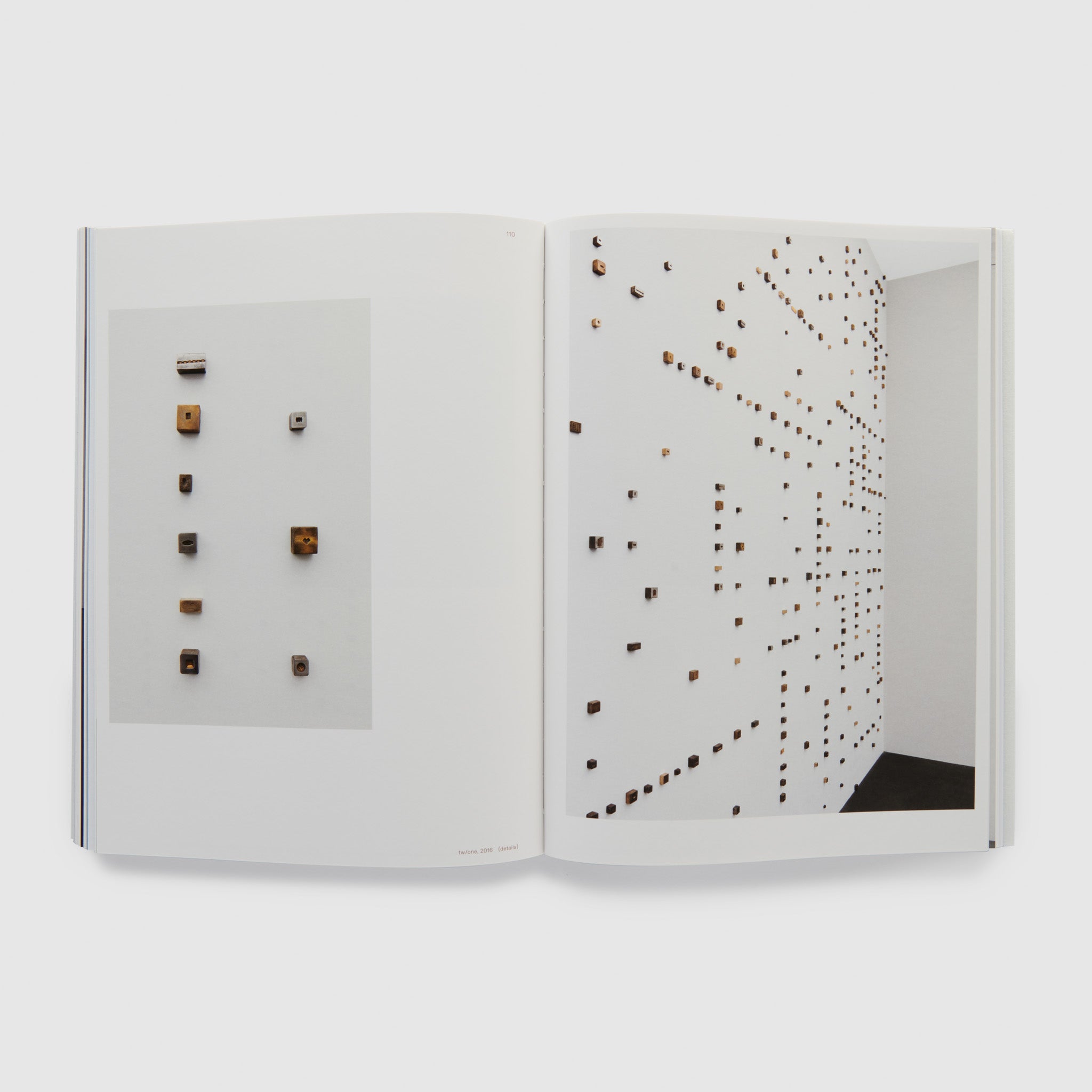 The book is open to two pages. The left page has a detail shot of the artists work and the right page shows the works installed on a white gallery wall.