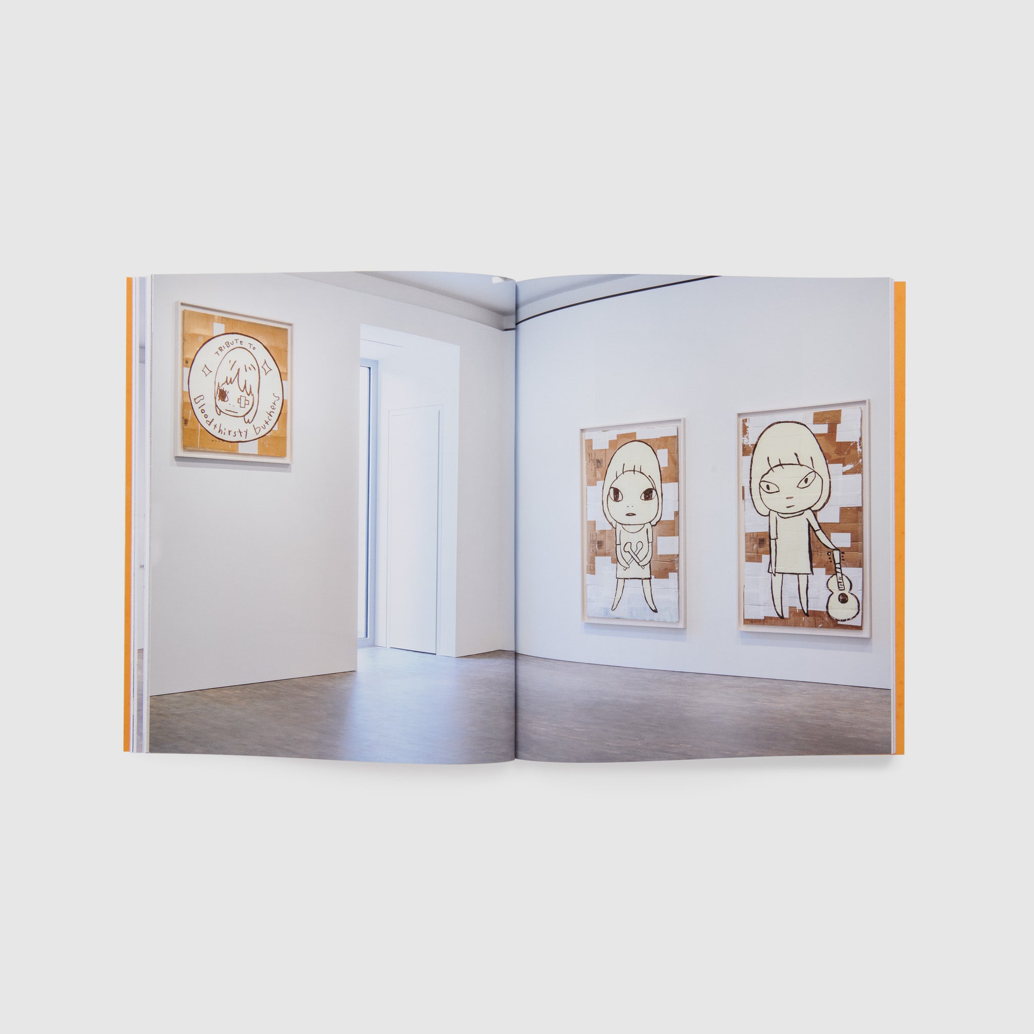 The book is open to two pages. There is one image across each page and it is of the gallery installation of the Nara exhibition.