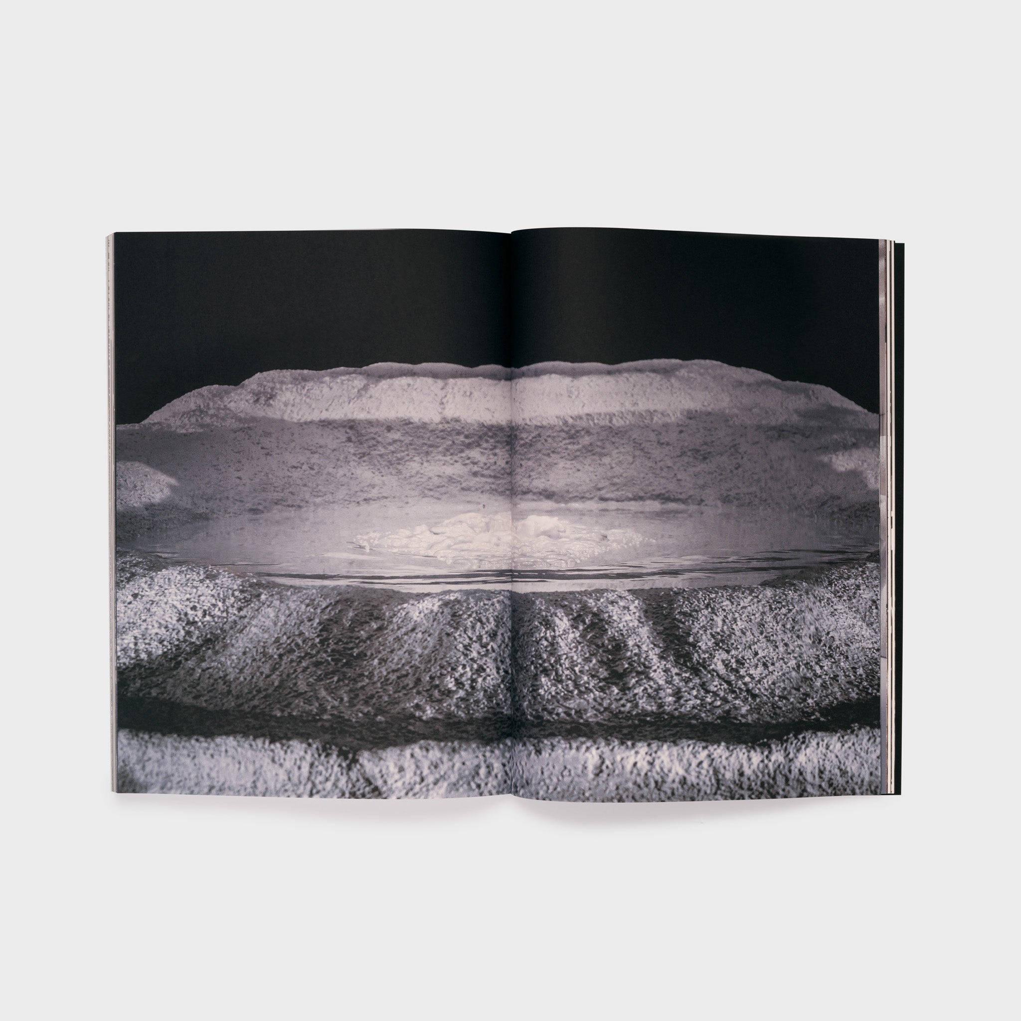 The book is open to two pages with a single Nawa black and white across both pages.