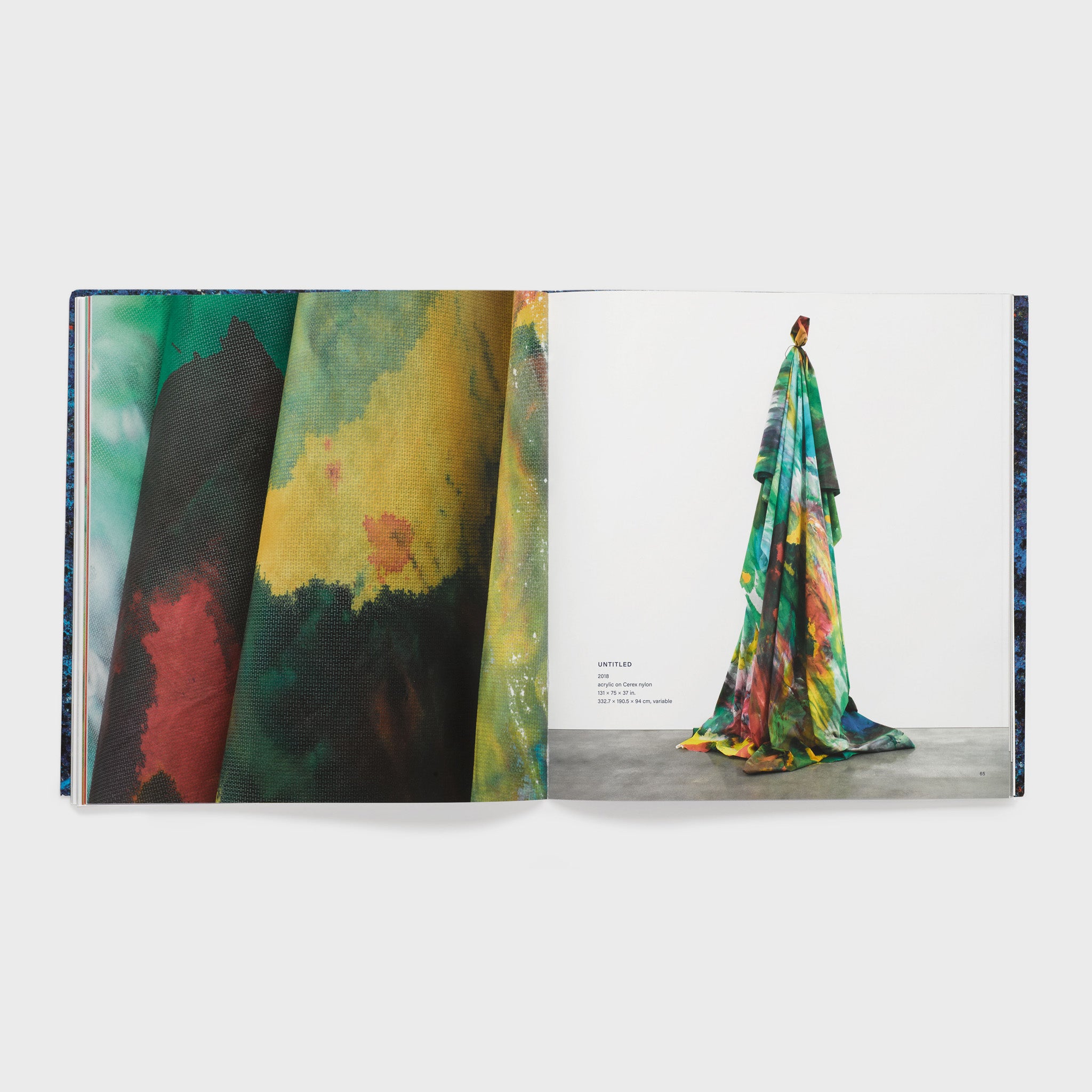 The book is open to two pages. The right page has an image of a draped Gilliam work in a white gallery with cement floors. The left page has a detail shot of the same work.