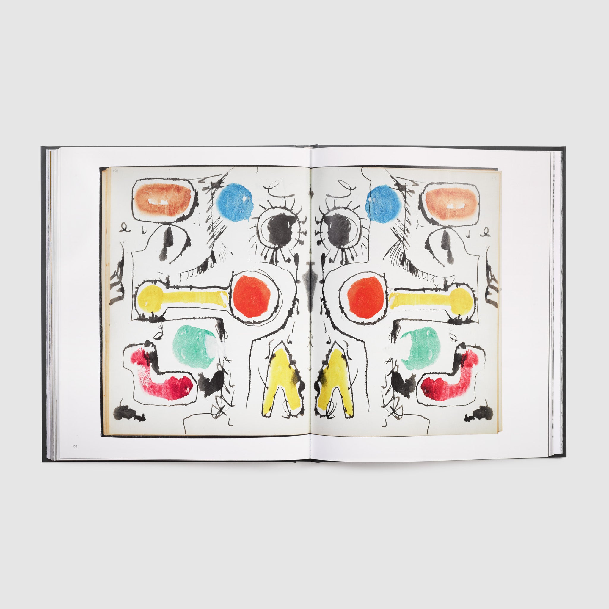 The book is open to two pages. There is a photograph of the artists painting that spans both pages.