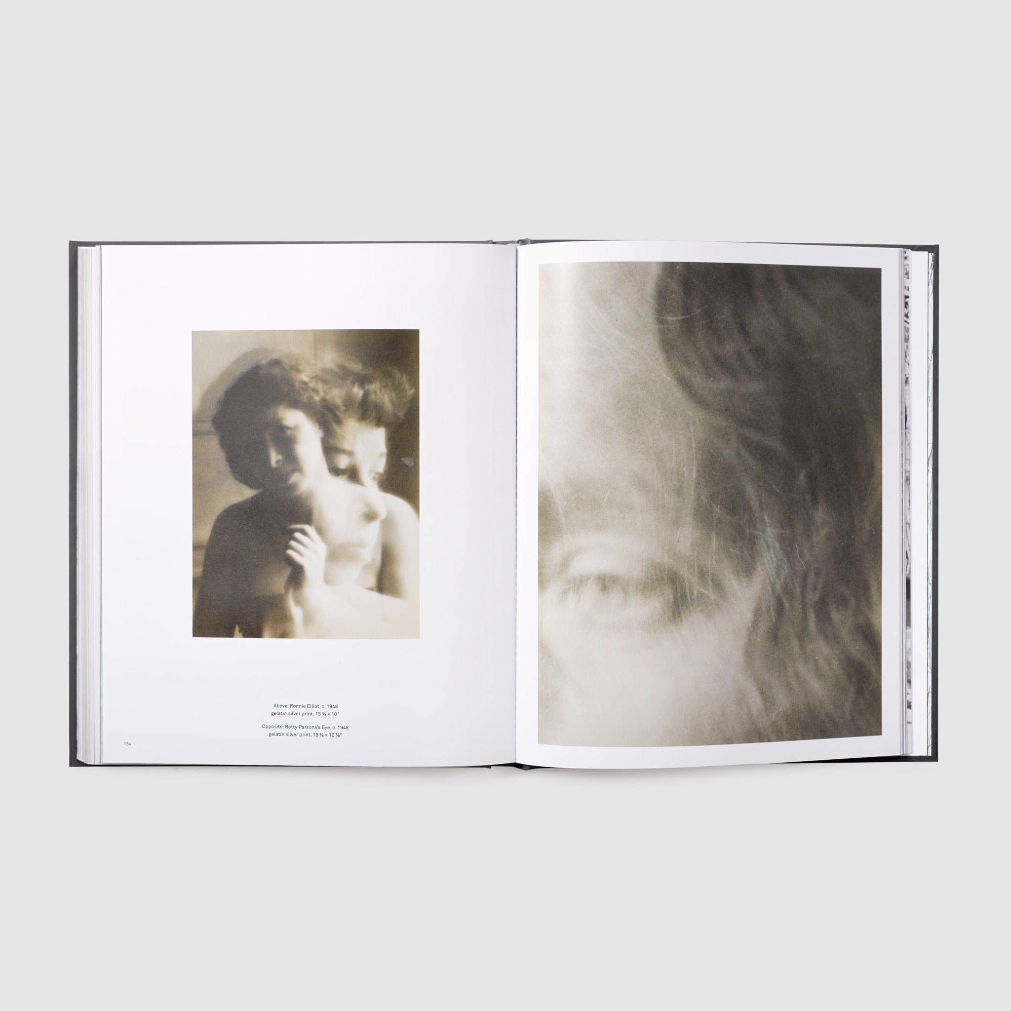The book is open to two pages. There is a black and white photograph on each page.