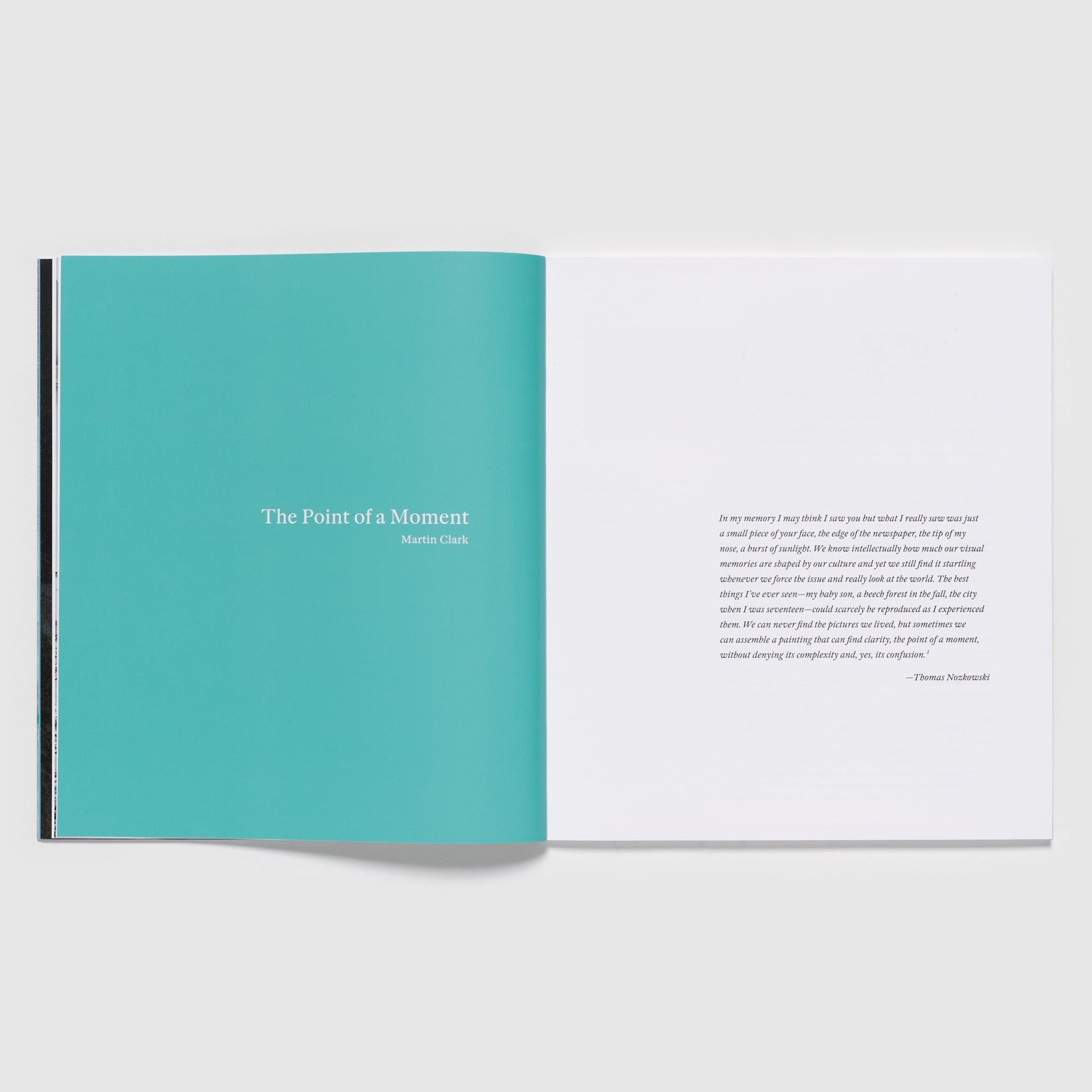 The book is open to two pages. The left page is blue with write font and has the title of an essay. The right page is white with black text and has a quote by the artist.