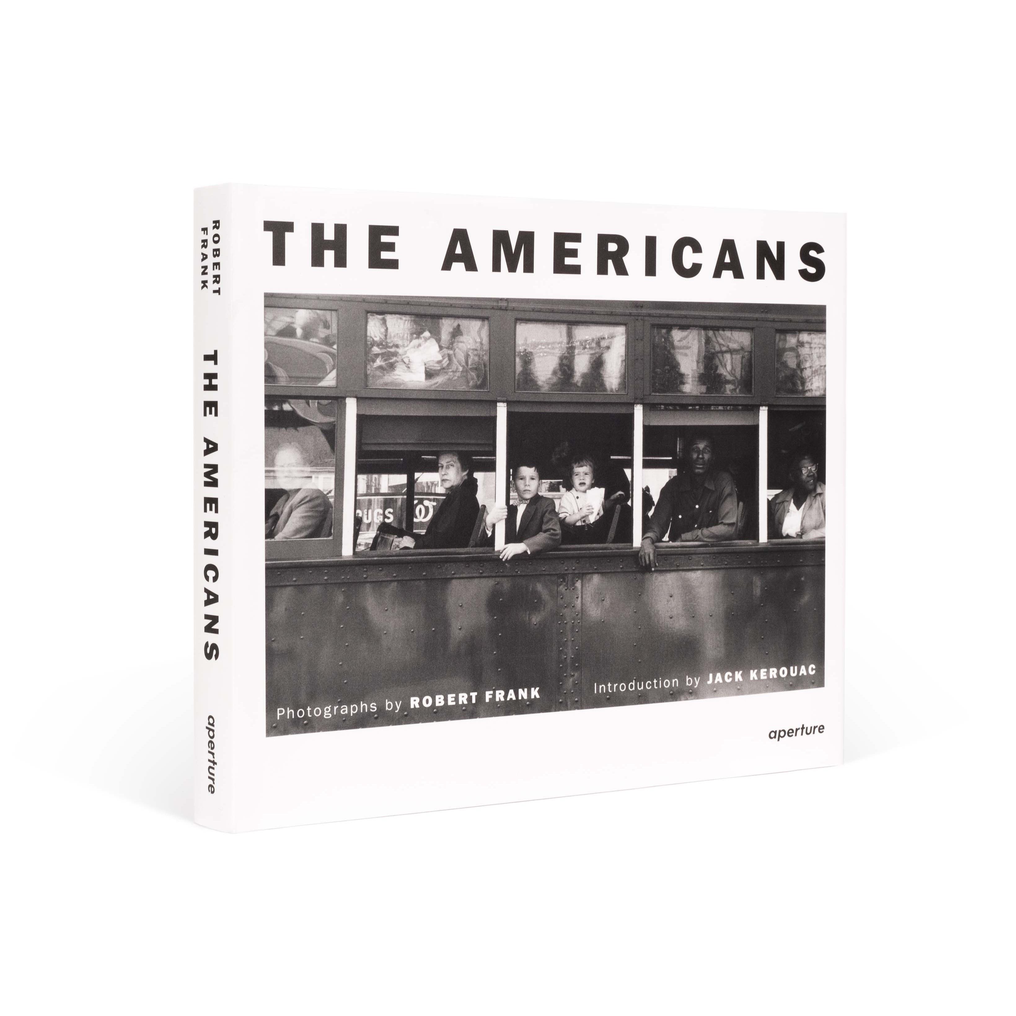 The book cover is white with the title "The Americans" in black letters. There is a black and white photo by Robert Frank on the cover.