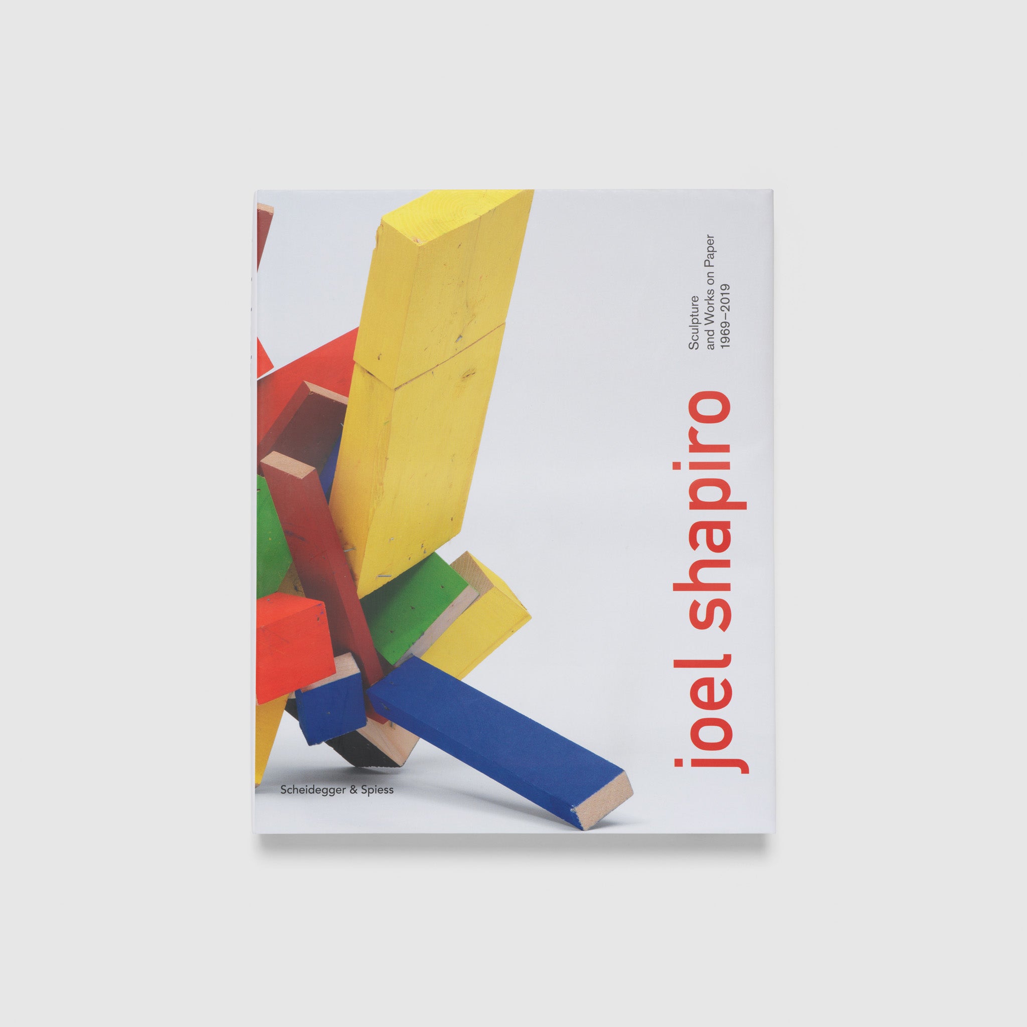 Joel Shapiro Sculpture and Works on Paper 1969-2019. The cover is white with an image of a yellow, green, red, and blue wooden sculpture on it.