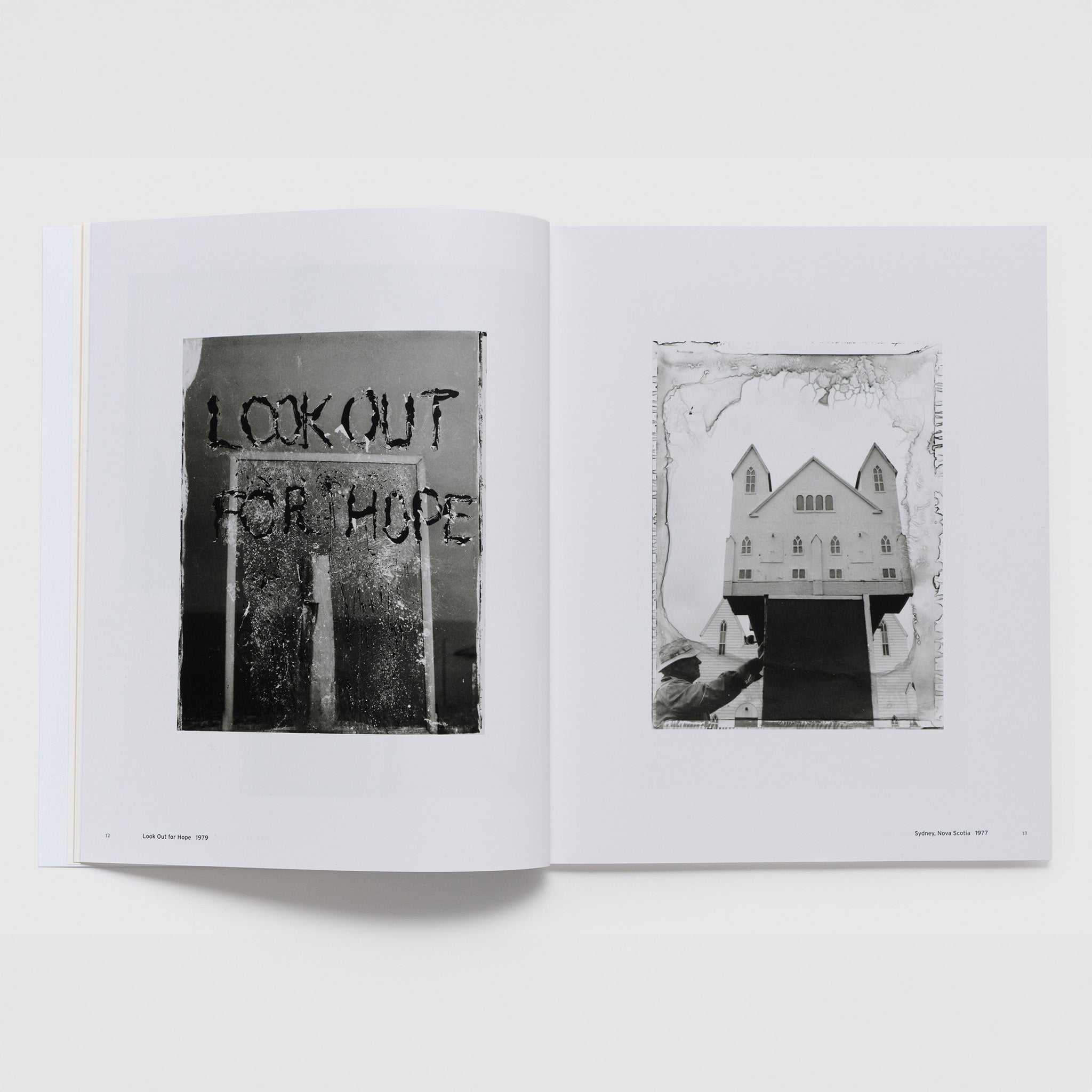 The book is open to two pages. Each page has a black and white photograph by Robert Frank on it.