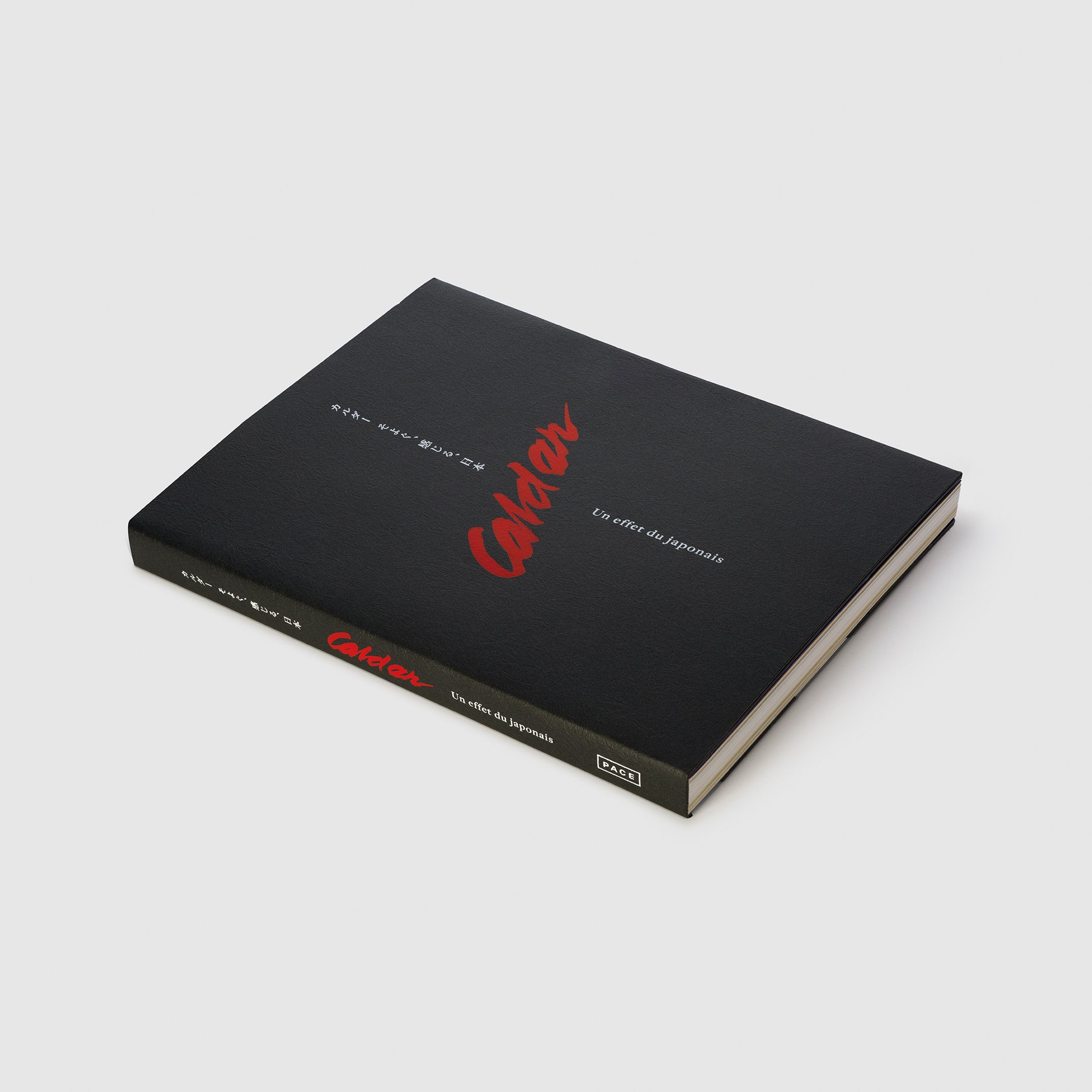 The book Calder Un Effet Du Japonais is laying flat. The black cover is textured with red and white font.