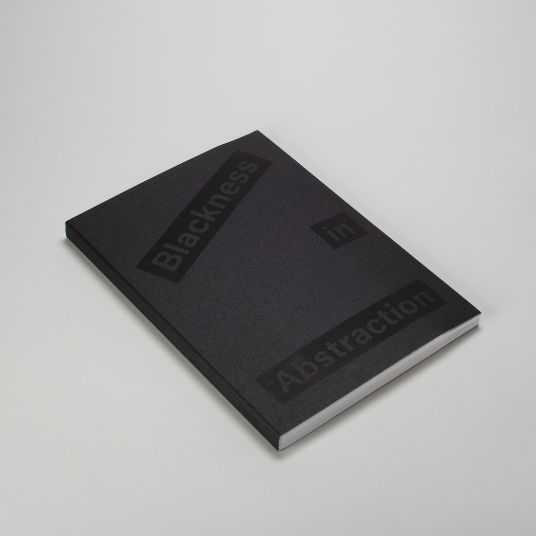 Blackness in Abstraction. The book is laying flat and has a black cloth cover with black font.