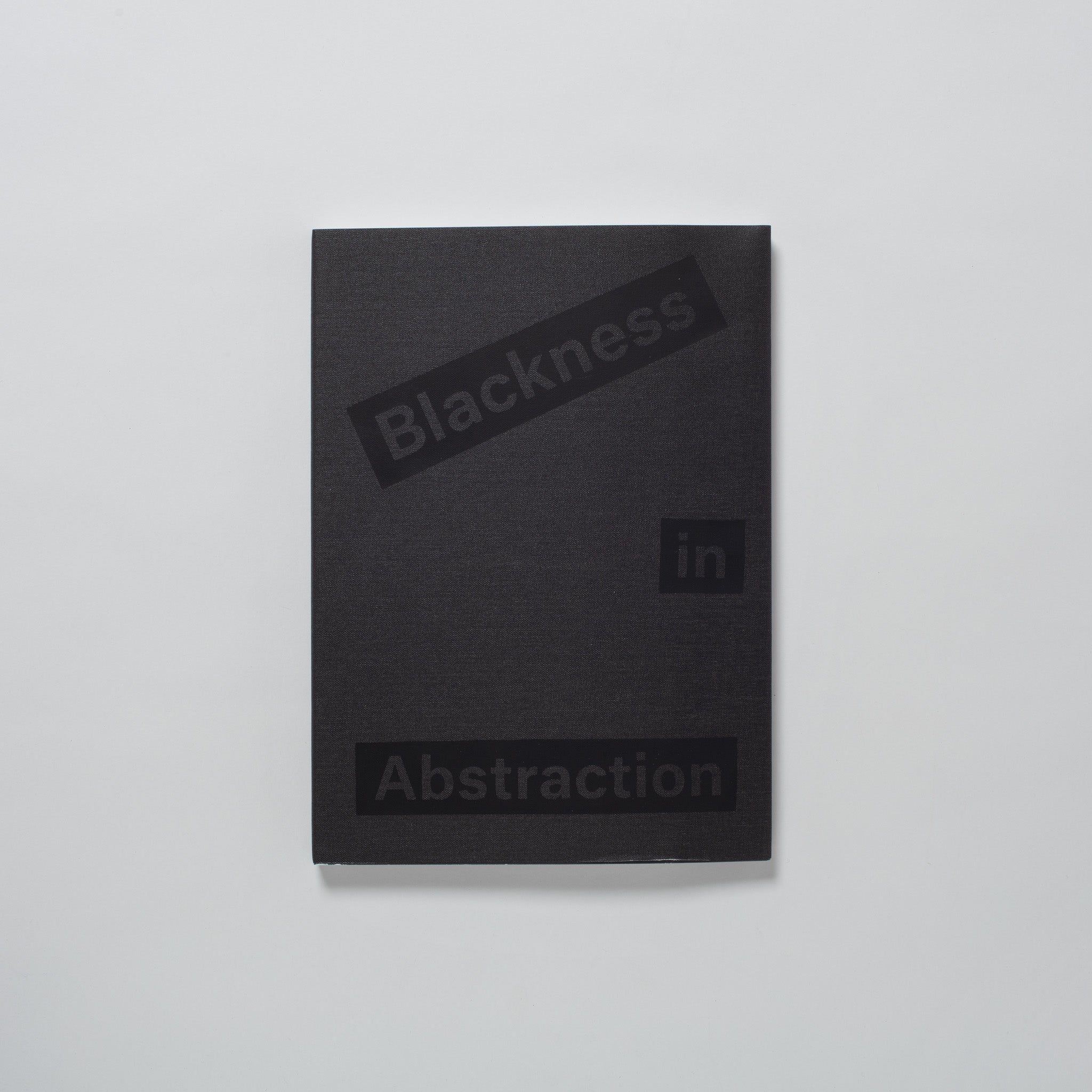 Blackness in Abstraction. The book is on a white background and has a black cloth cover and black font.