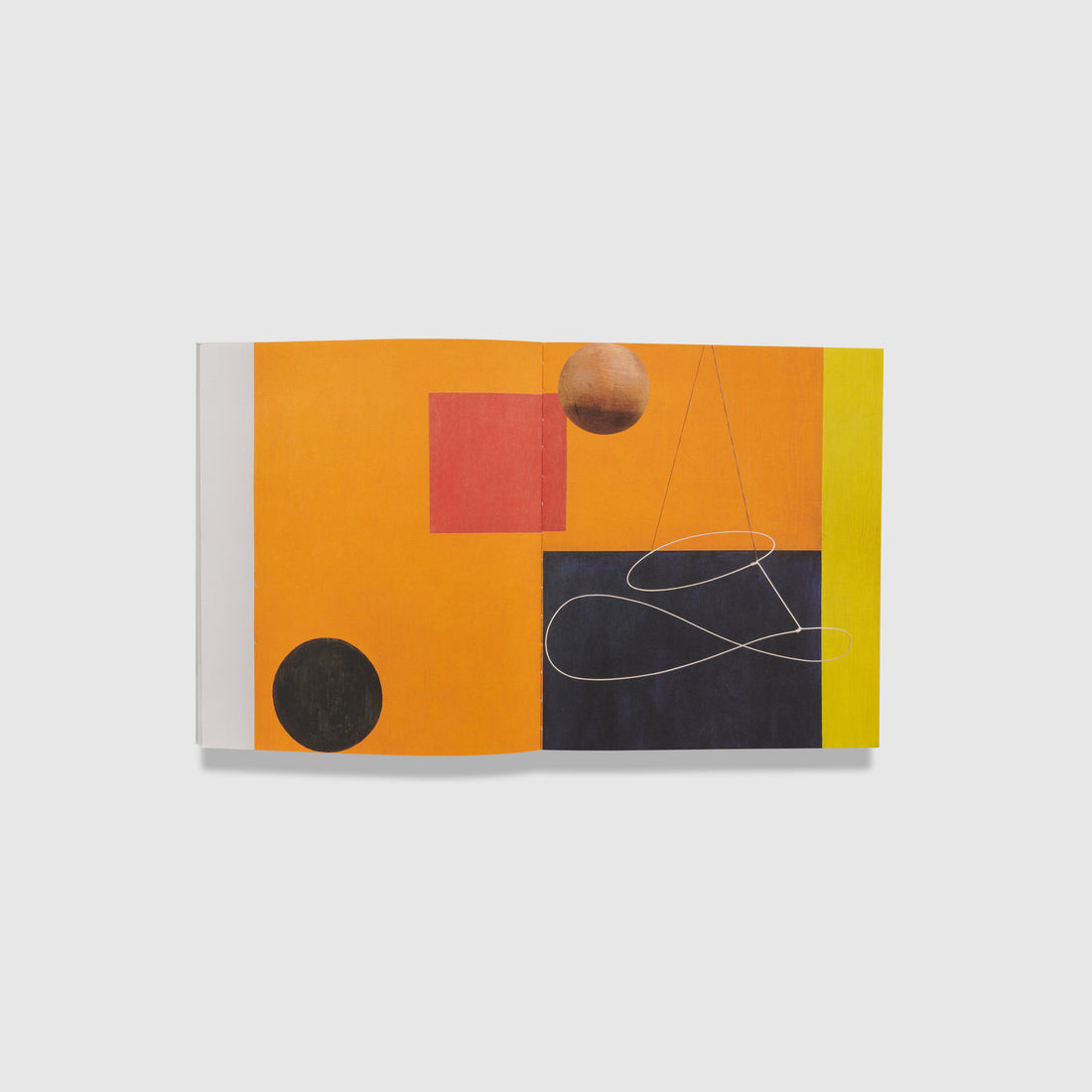 The book is open to two pages with one painting by Alexander Calder across both of them. The painting has black, orange, yellow, red, and brown shapes.
