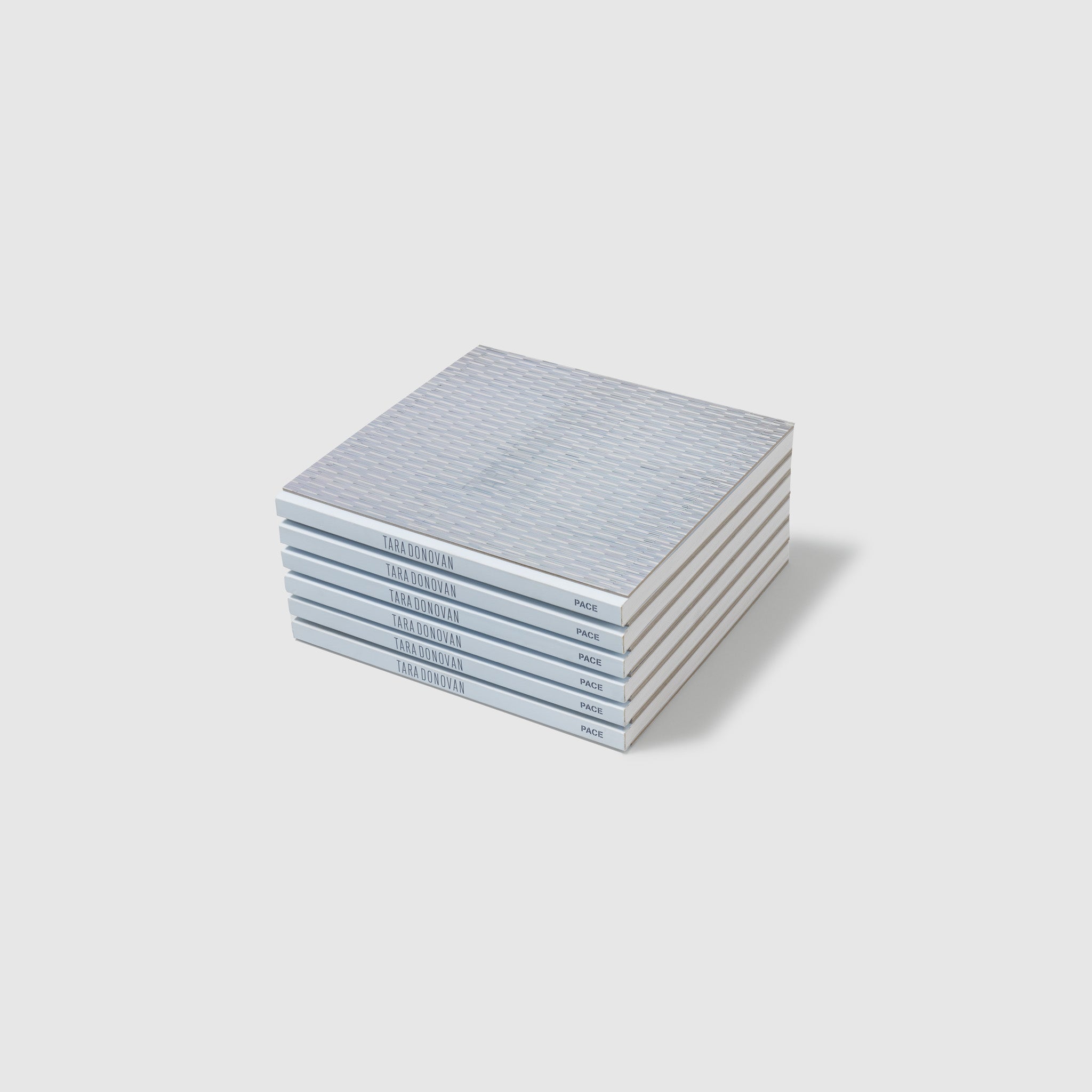Six Tara Donovan Compositions books are stacked on top of each other.