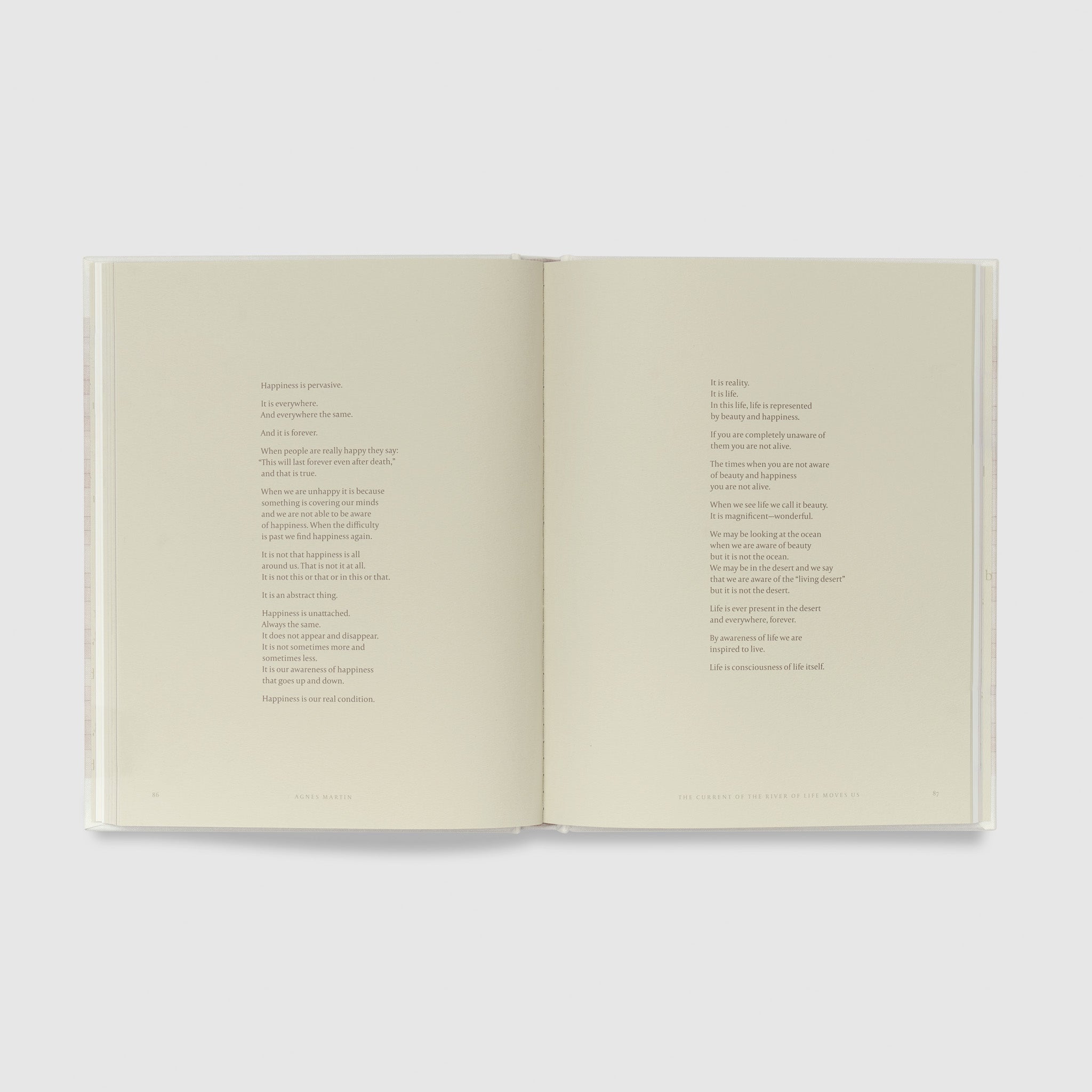 The book is open to two pages that have a poem across both written in black text.