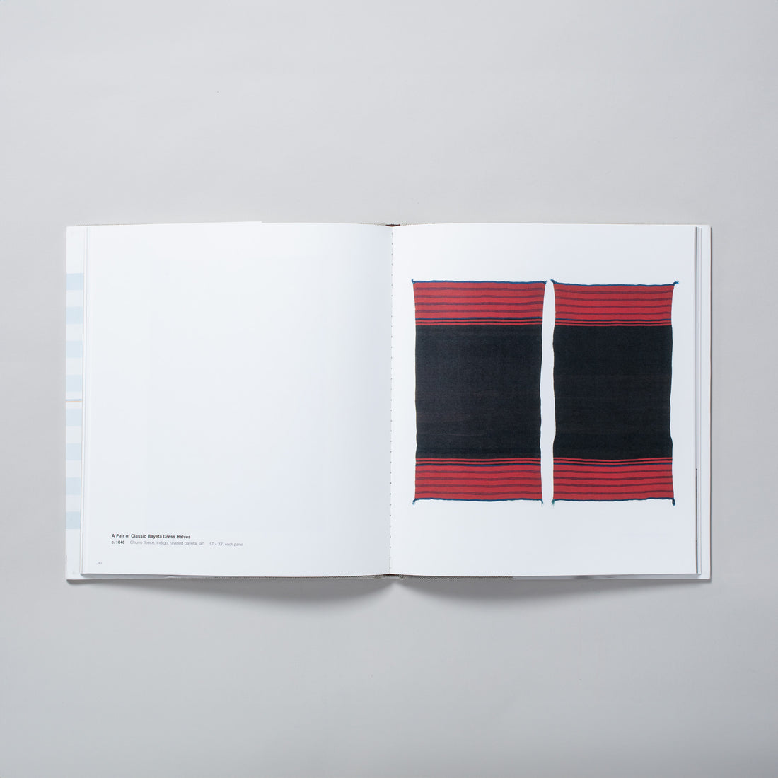The book is open to two pages, with two red and black Navajo blankets on a white background on the white page and black text about the blankets on the left. 