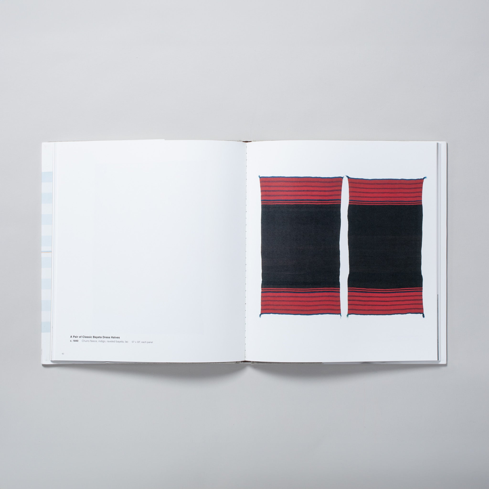 The book is open to two pages, with two red and black Navajo blankets on a white background on the white page and black text about the blankets on the left. 