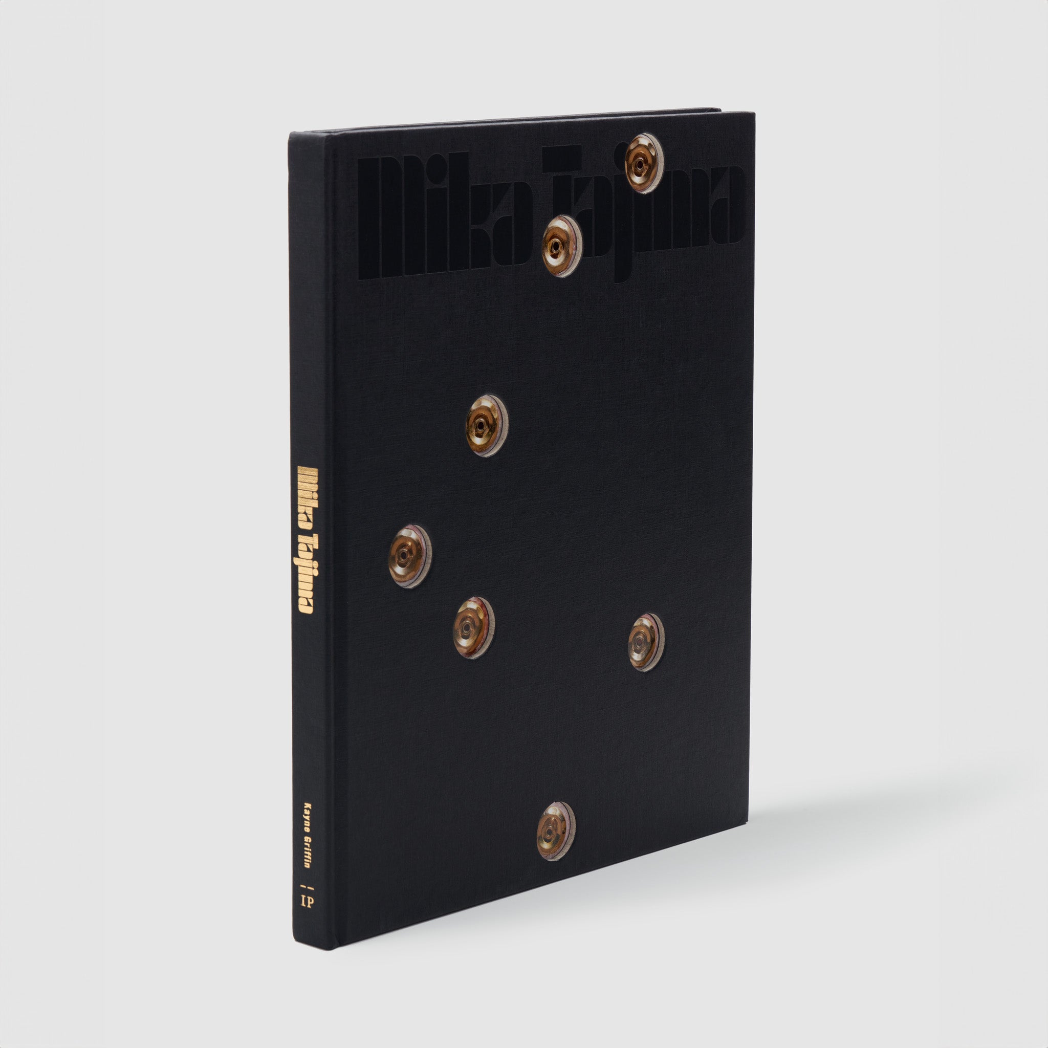 Mika Tajima. The book has a black cover with gold hot tub nozzle details.