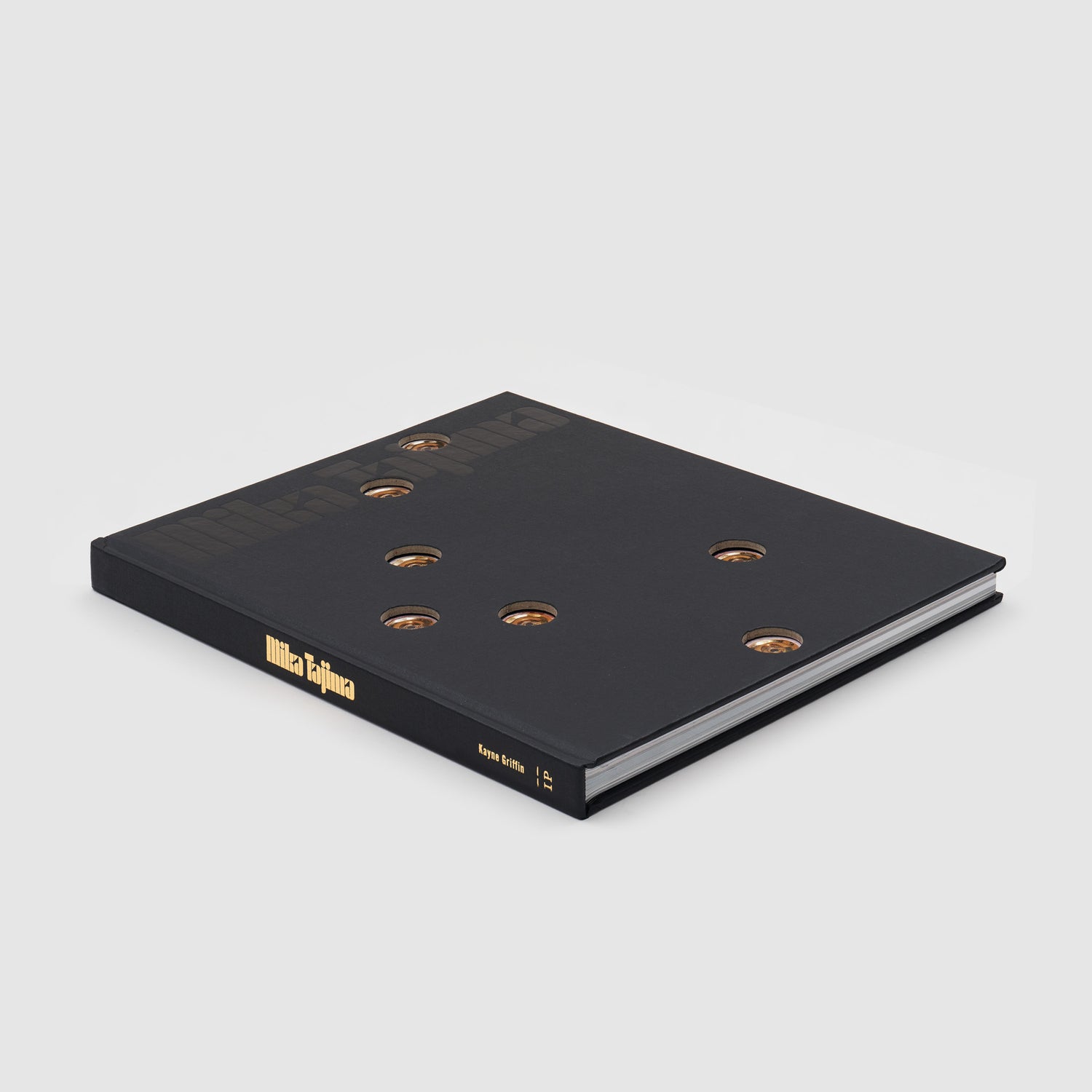 Mika Tajima. The book has a black cover with gold hot tub nozzle details.