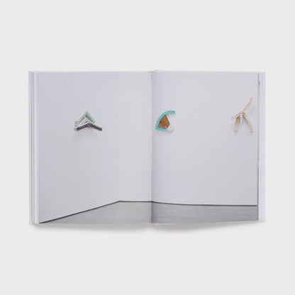 The book is open to two pages and has the same installation image in the gallery across both pages.