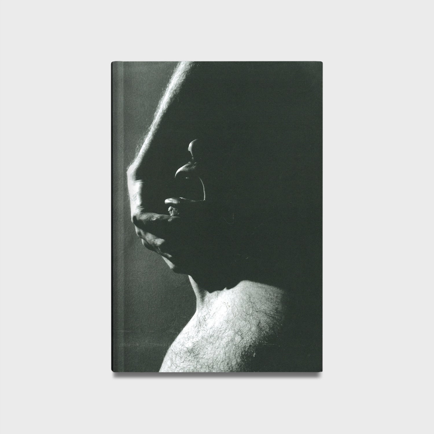Book cover with a black and white photograph of a hand on a face against a plain background. 
