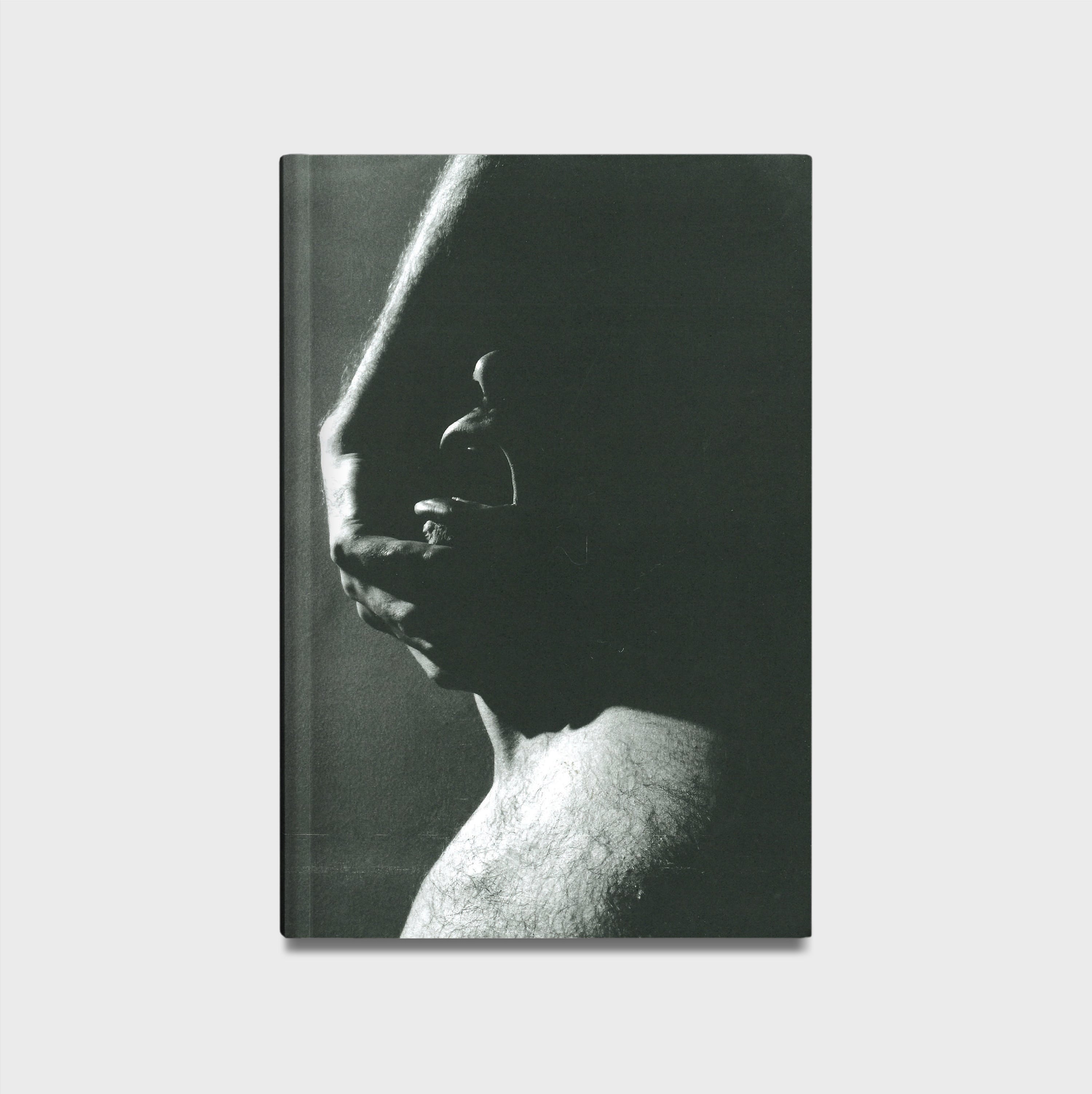 Book cover with a black and white photograph of a hand on a face against a plain background. 